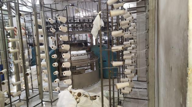 Fabric rolls off the knitting machine